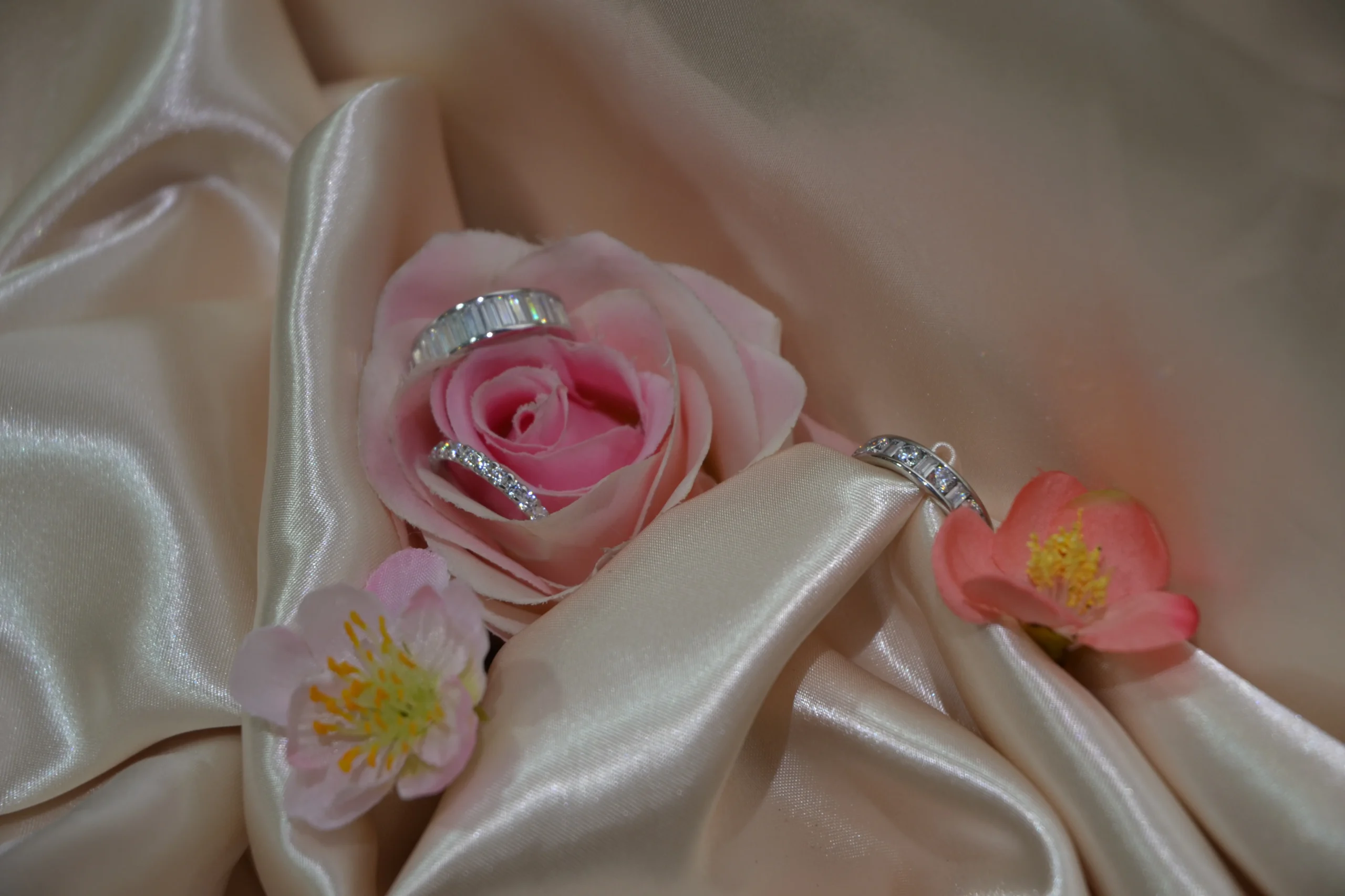 Bespoke diamond eternity and wedding bands featuring baguette and round cuts resting inside a pink rose, crafted by Alexander Jewellery Chichester.